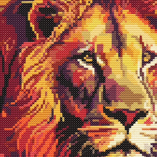 Lion Cross Stitch Pattern close-up featuring detailed lion eyes, bold orange and gold tones, and visible counted cross stitch texture.