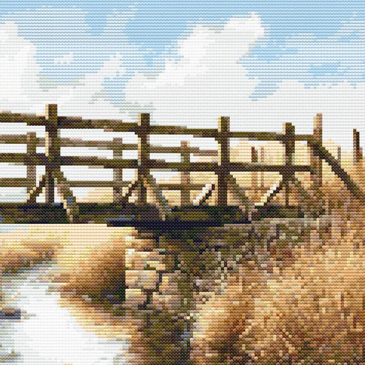 Wooden bridge over a river with a blue sky and clouds in the background
