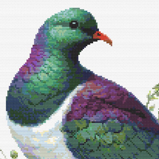 Close-up of New Zealand Kererū Cross Stitch Pattern showing the bird’s green head, purple chest, red beak, and visible counted cross stitch texture.