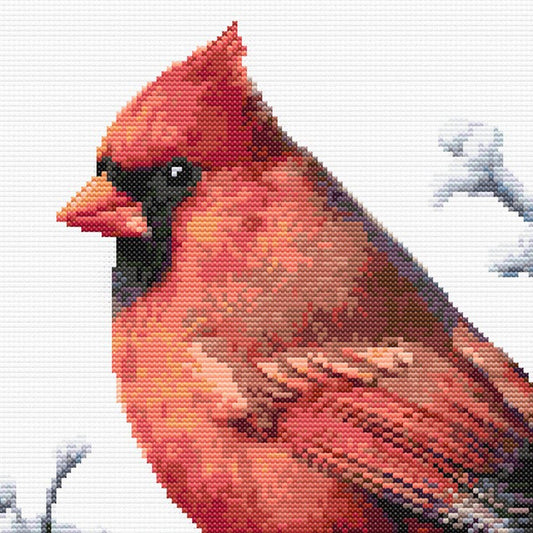 Close-up of Northern Cardinal Bird Cross Stitch Pattern showing snowy branches, red feather detail, and winter bird styling.