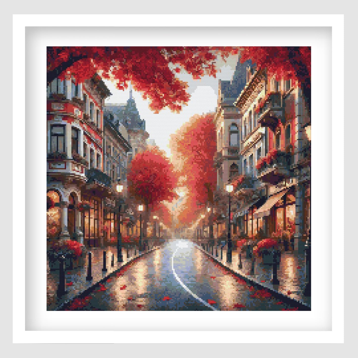 Autumn city street cross stitch pattern featuring a glowing rain-soaked road lined with red trees, historic buildings, shopfronts and warm reflected lights.