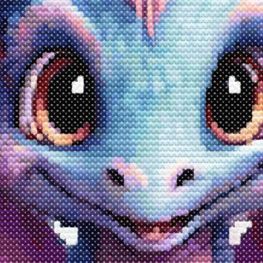 A  close up view of the baby dragon cross stitch pattern showing the eyes and face of purple and blue dragon.