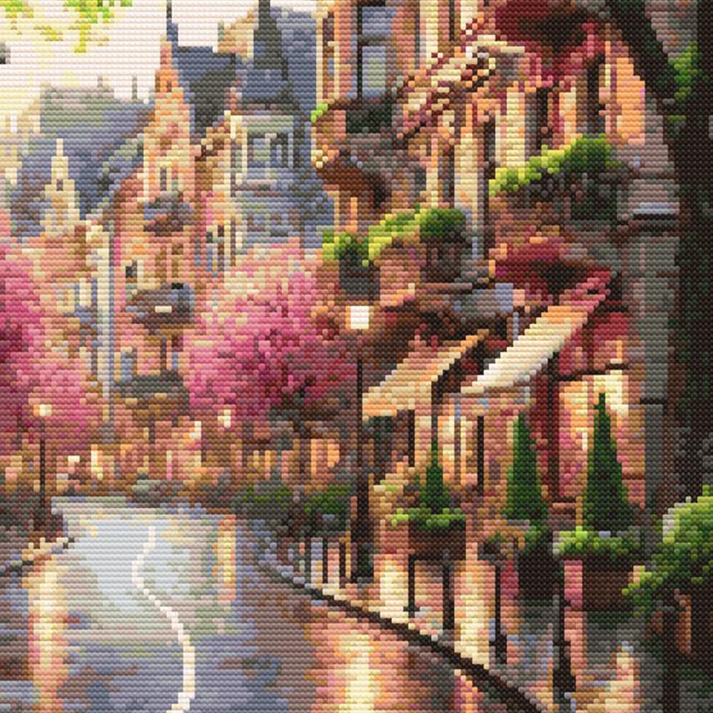 Cityscape Spring Lane Cross Stitch Pattern featuring a charming street scene with pink spring trees, detailed buildings, warm light, and scenic city wall art style.