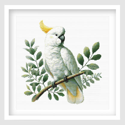 White cockatoo cross stitch pattern featuring a yellow-crested bird perched on a branch with soft green foliage, designed as a detailed wildlife digital PDF chart.