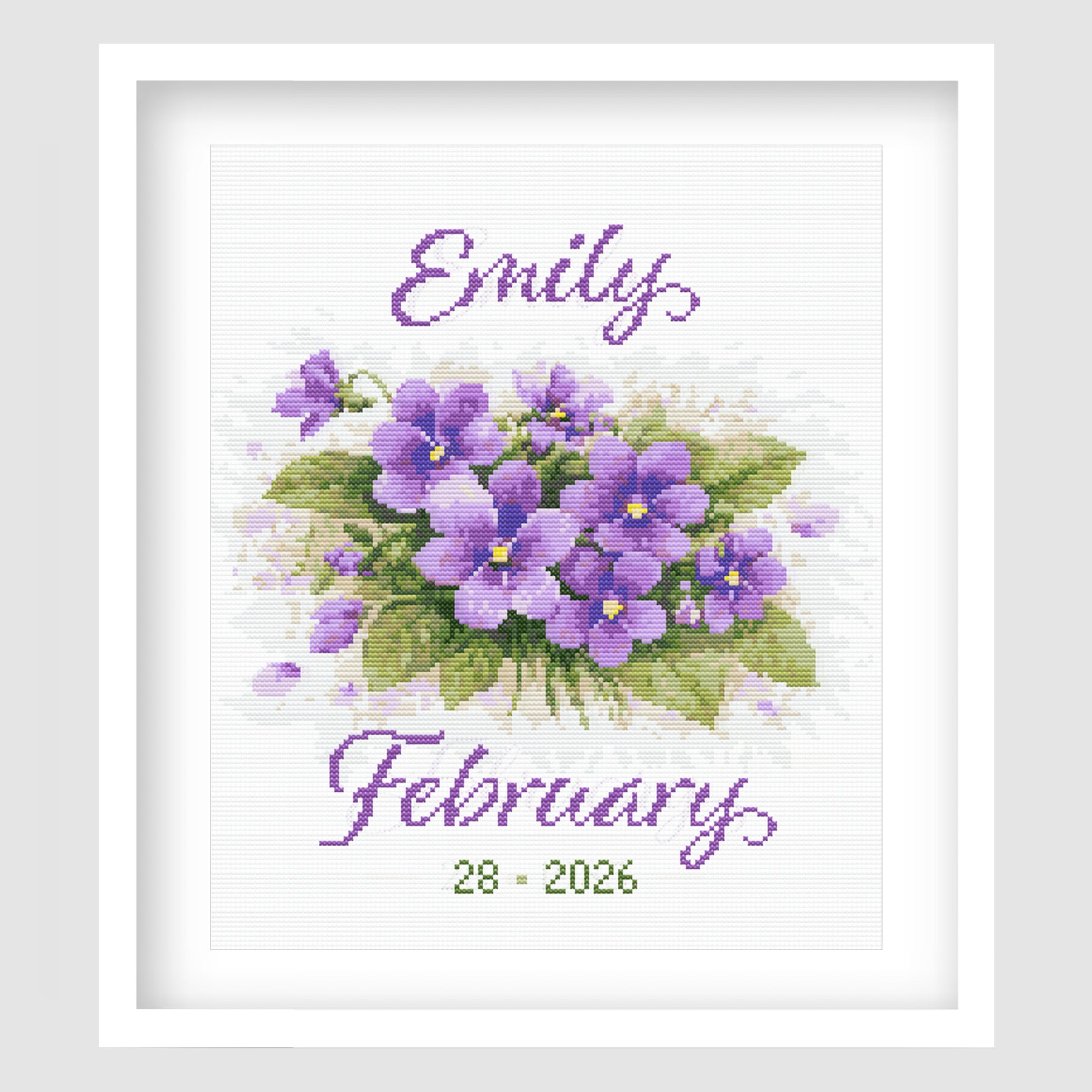 February Birth Flower Cross Stitch Pattern displayed in a white frame, featuring purple violets with a personalised baby name and birth date.