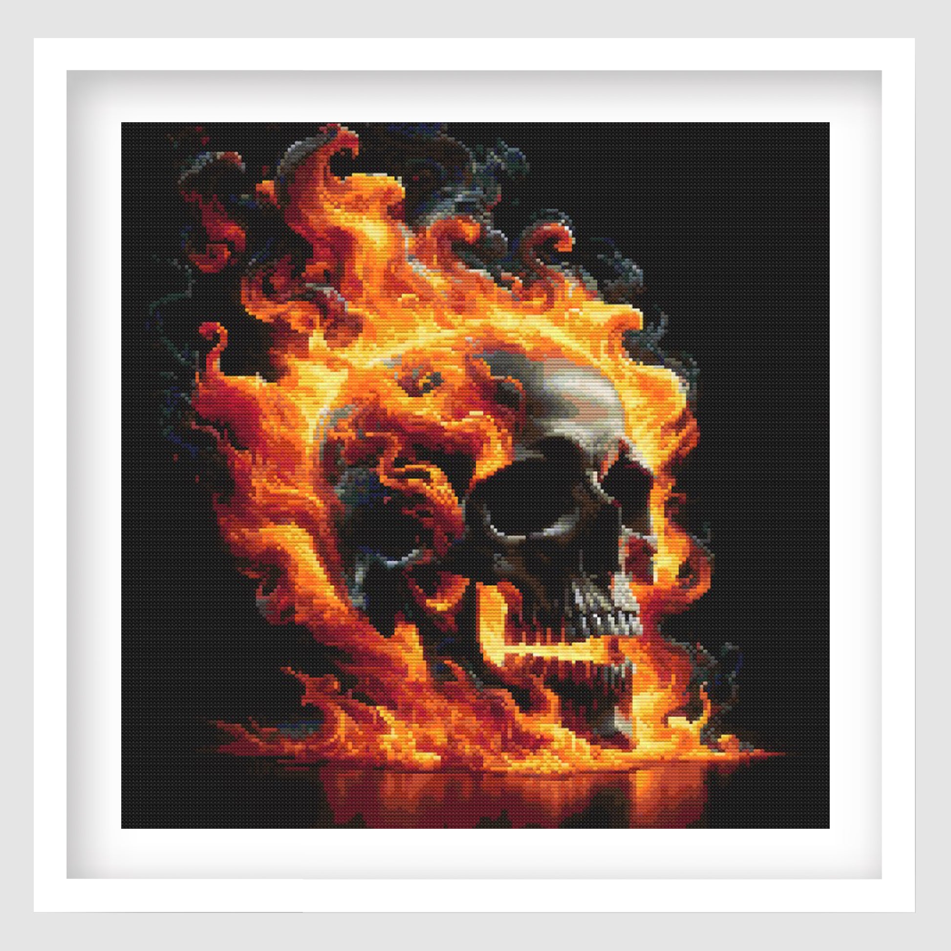 Flaming Skull Cross Stitch Pattern shown in a white frame, featuring a black skull surrounded by vivid orange flames on a dark gothic background.