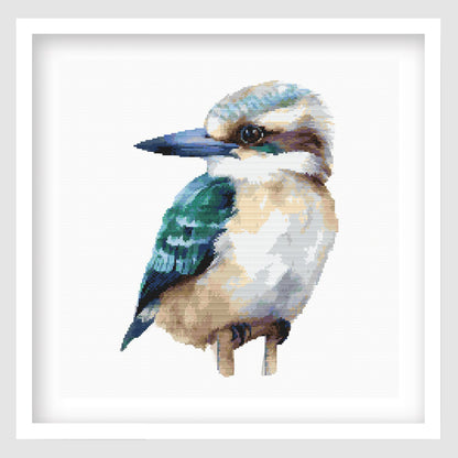 Kookaburra cross stitch pattern featuring a detailed blue, cream and brown bird design, shown as framed wall art.