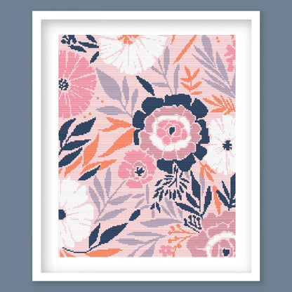 Modern Floral Cross Stitch Pattern featuring soft pink flowers, navy leaves and botanical details in a framed design.