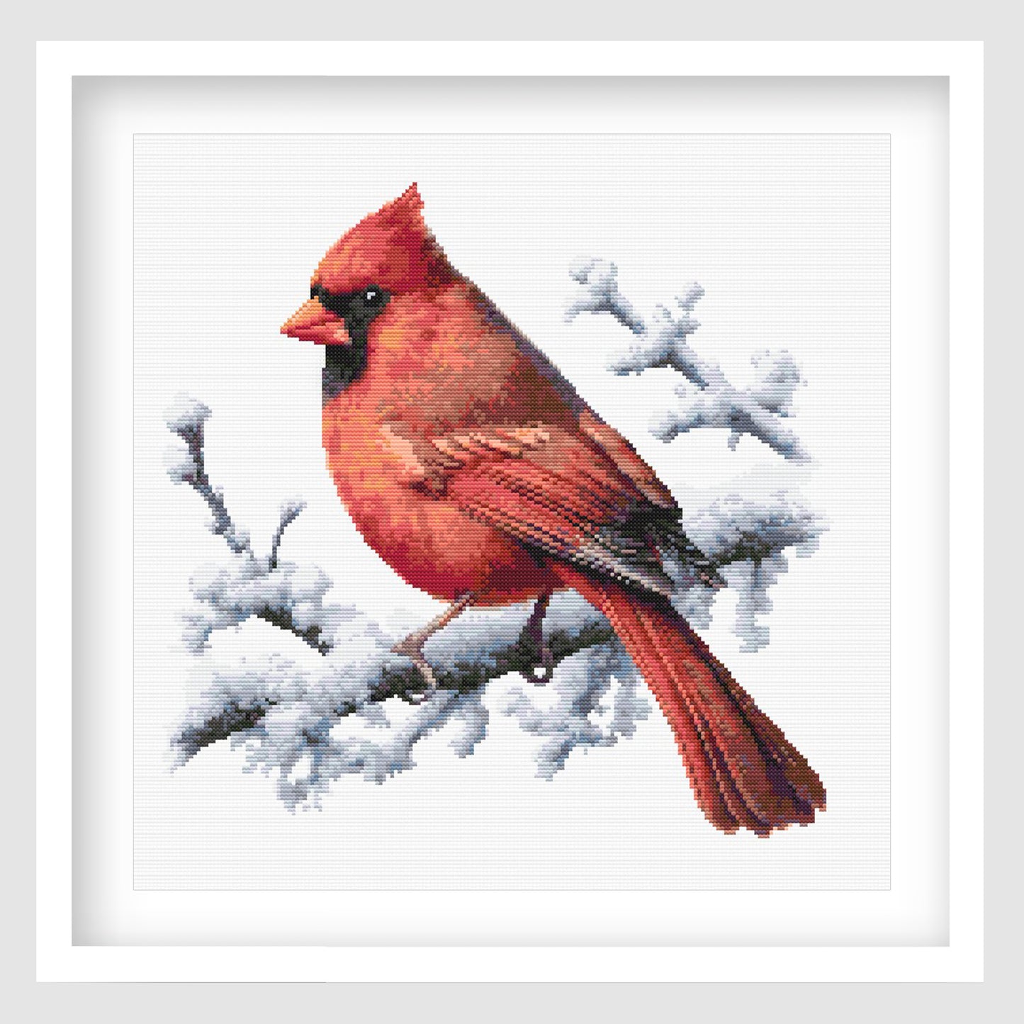 Cardinal cross stitch pattern featuring a bright red bird perched on a snowy branch, with detailed feathers and a soft winter wildlife design.