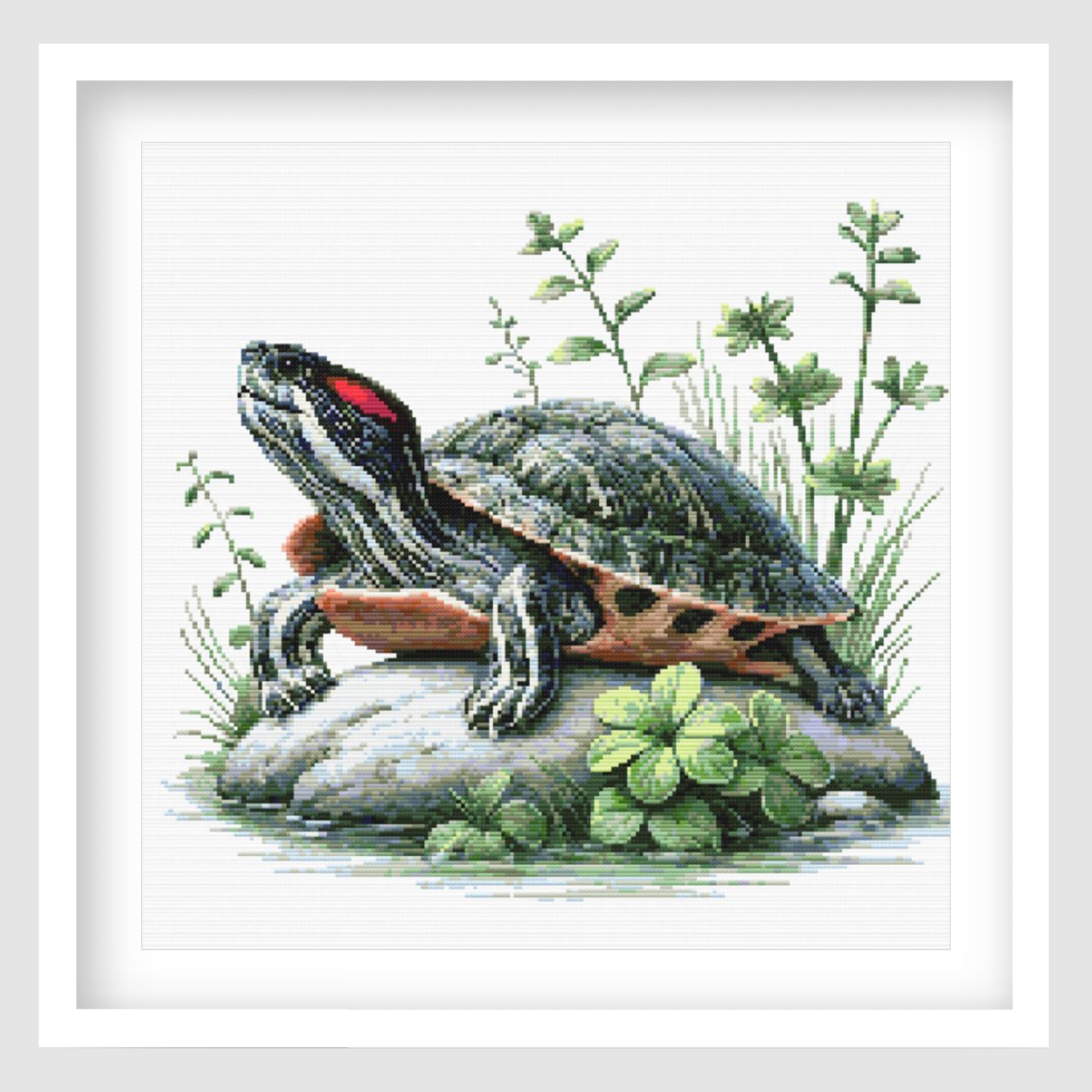 Turtle cross stitch pattern featuring a detailed pond turtle resting on rocks, surrounded by green plants, clover leaves and natural wildlife details.