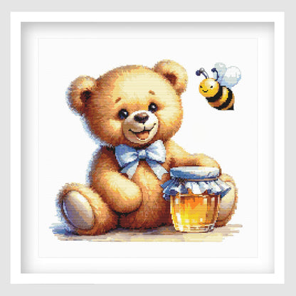 Teddy bear cross stitch pattern featuring a smiling golden bear with a blue bow, honey jar and buzzing bee, designed as a cute nursery or baby gift project.