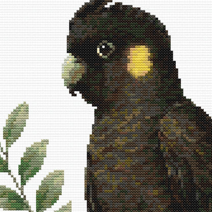 Yellow-Tailed Black Cockatoo Cross Stitch Pattern close-up highlighting the bird's distinctive dark feathers, yellow cheek patch and realistic wildlife details.