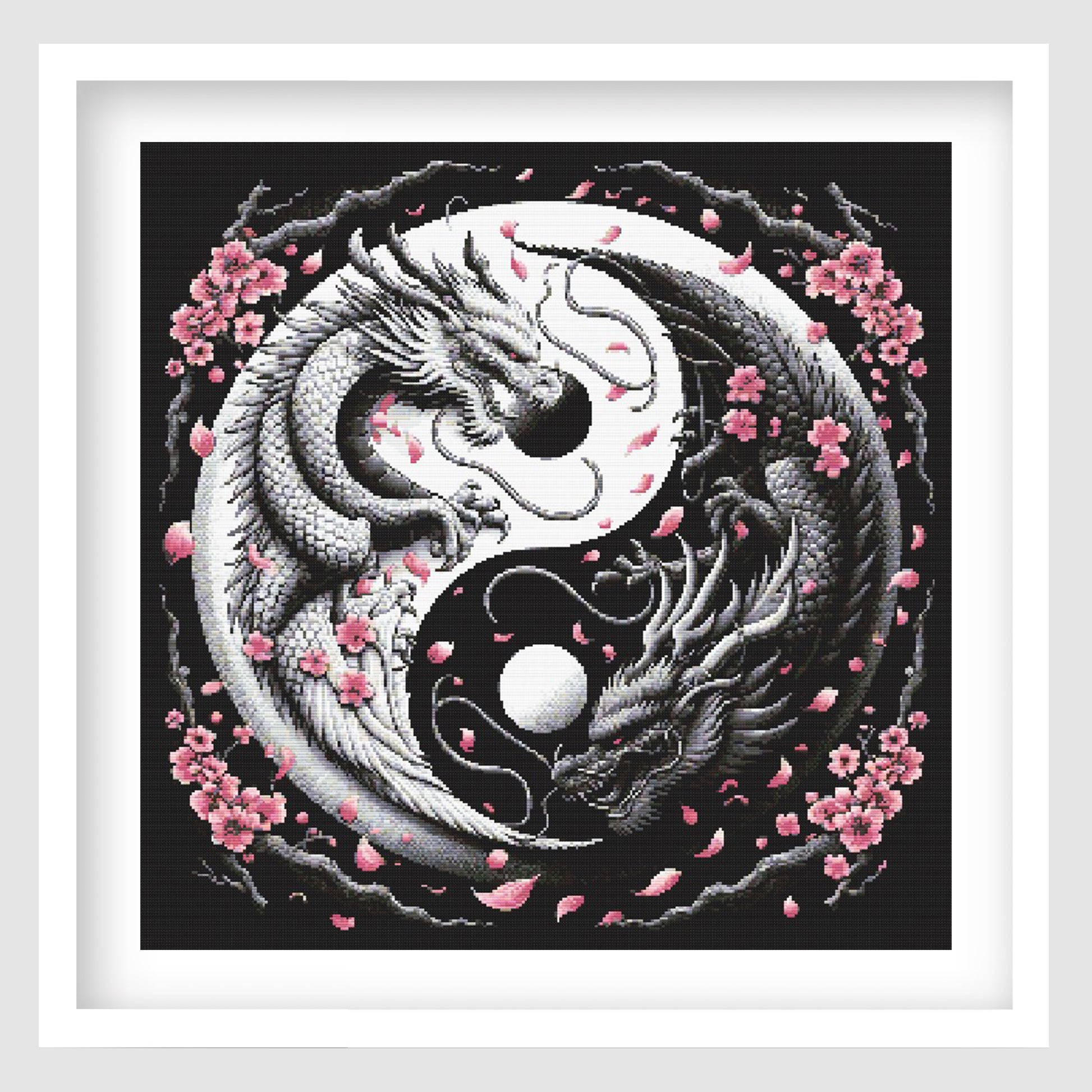 Yin yang dragon cross stitch pattern featuring two detailed black and white dragons curled around a moon-style symbol, with pink cherry blossoms and falling petals on a dark background.