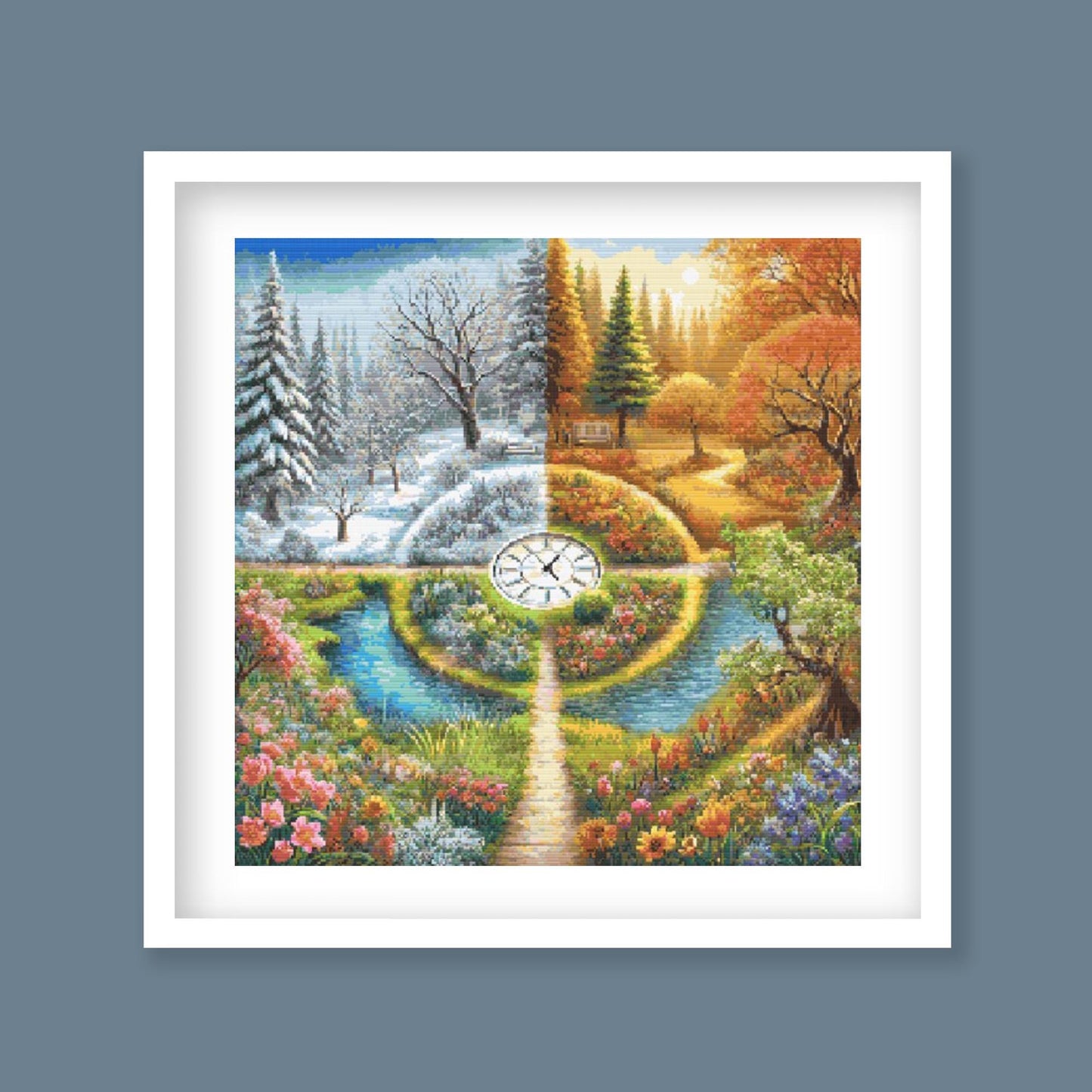 A Stitch in Time Cross Stitch Pattern displayed as framed wall art with a seasonal garden landscape, winding paths, water, flowers, trees, and changing seasonal colour.