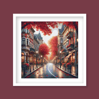 Autumn Cityscape Cross Stitch Pattern displayed as framed wall art with glowing red trees, warm street lighting, city buildings, and seasonal urban detail.
