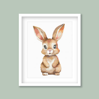 Baby Rabbit Cross Stitch Pattern displayed as framed wall art with a soft bunny design on a sage green background for nursery or kids room decor.