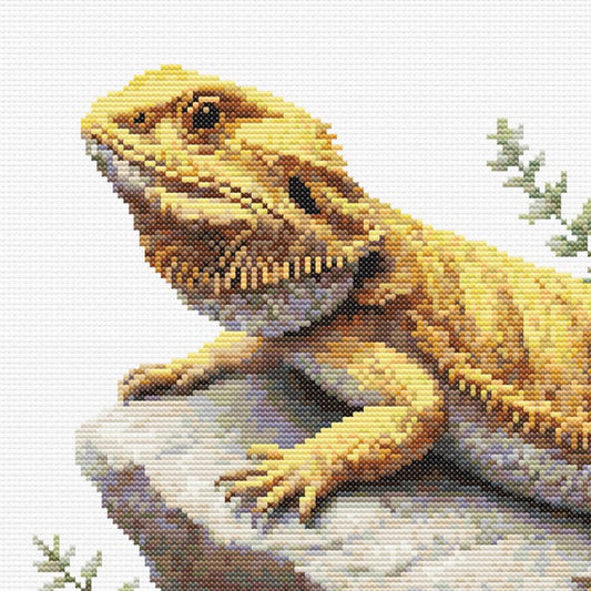 Cross-stitched lizard on a rock with a light background
