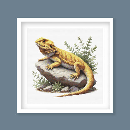 Framed artwork of a bearded dragon on a rock with plants in a white frame with blue background.