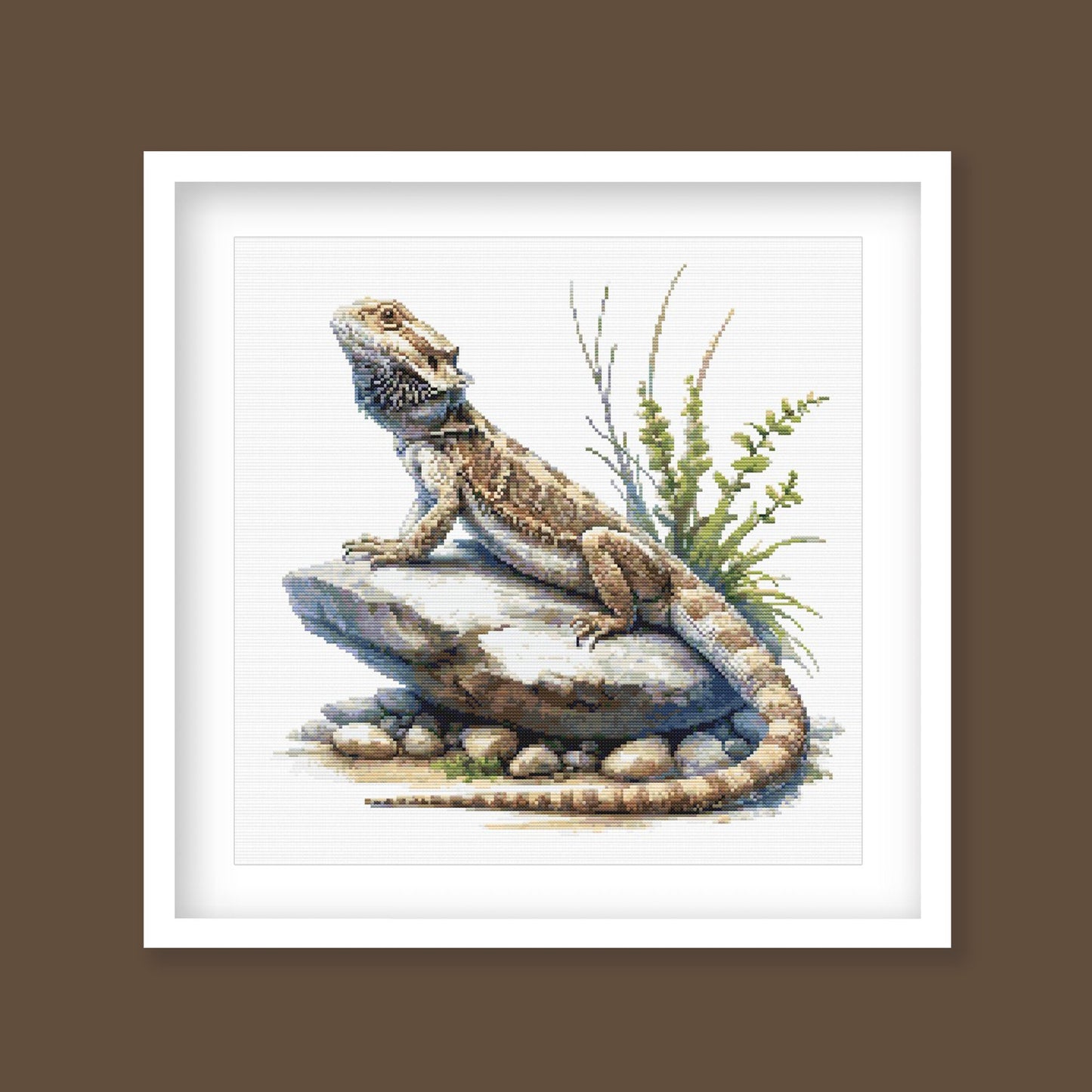 Bearded Dragon Lizard Cross Stitch Pattern displayed as framed wall art with a detailed reptile, textured scales, rocky ground, and natural desert-style detail.
