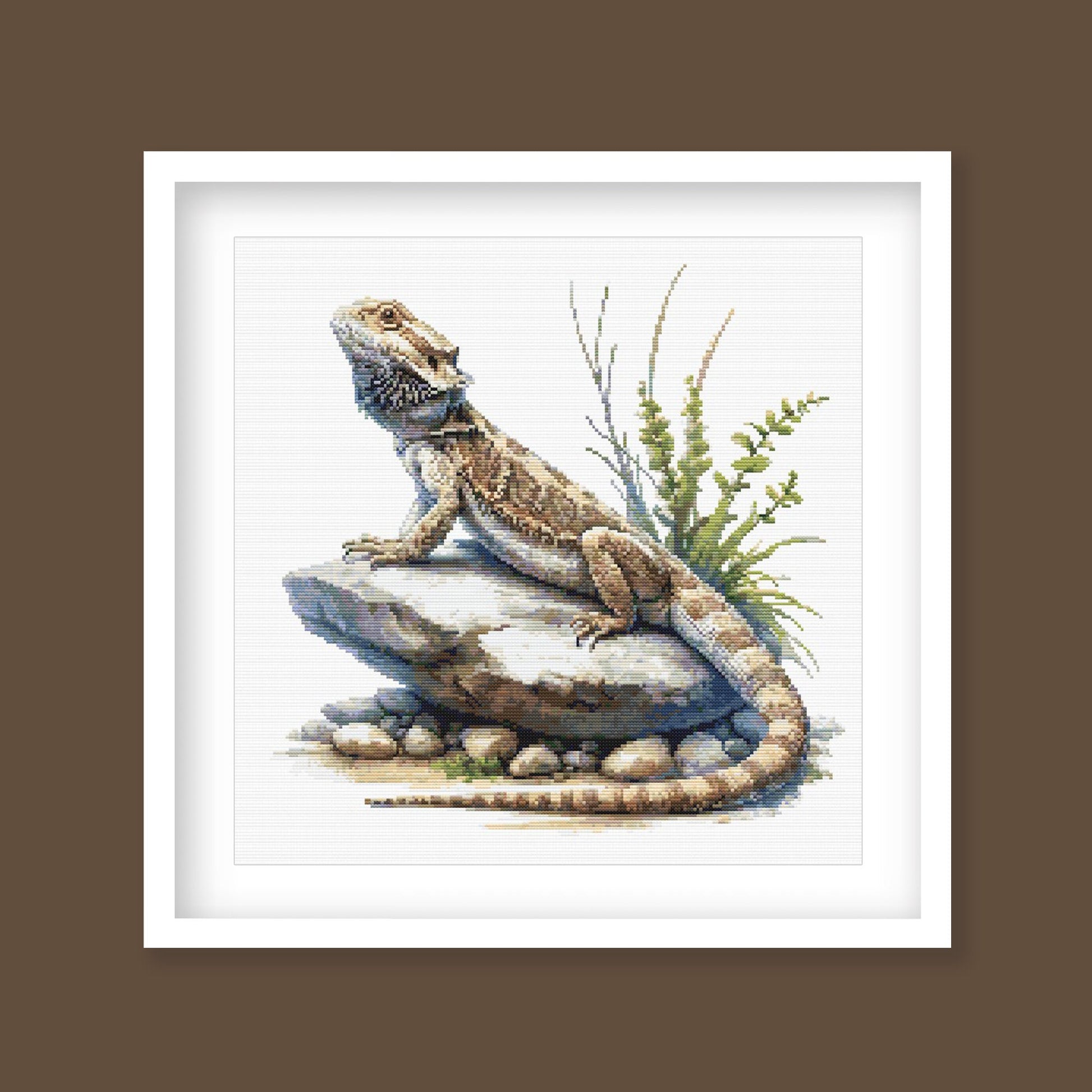 Bearded Dragon Lizard Cross Stitch Pattern displayed as framed wall art with a detailed reptile, textured scales, rocky ground, and natural desert-style detail.
