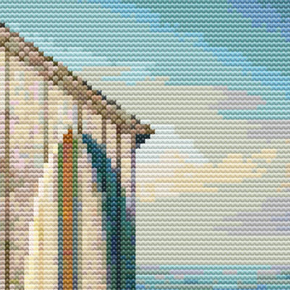 Close-up of Boat Shed Cross Stitch Pattern showing the side of the boat shed, soft blue sky, and coastal landscape detail.