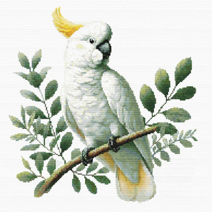 White parrot with yellow crest on a branch with green leaves