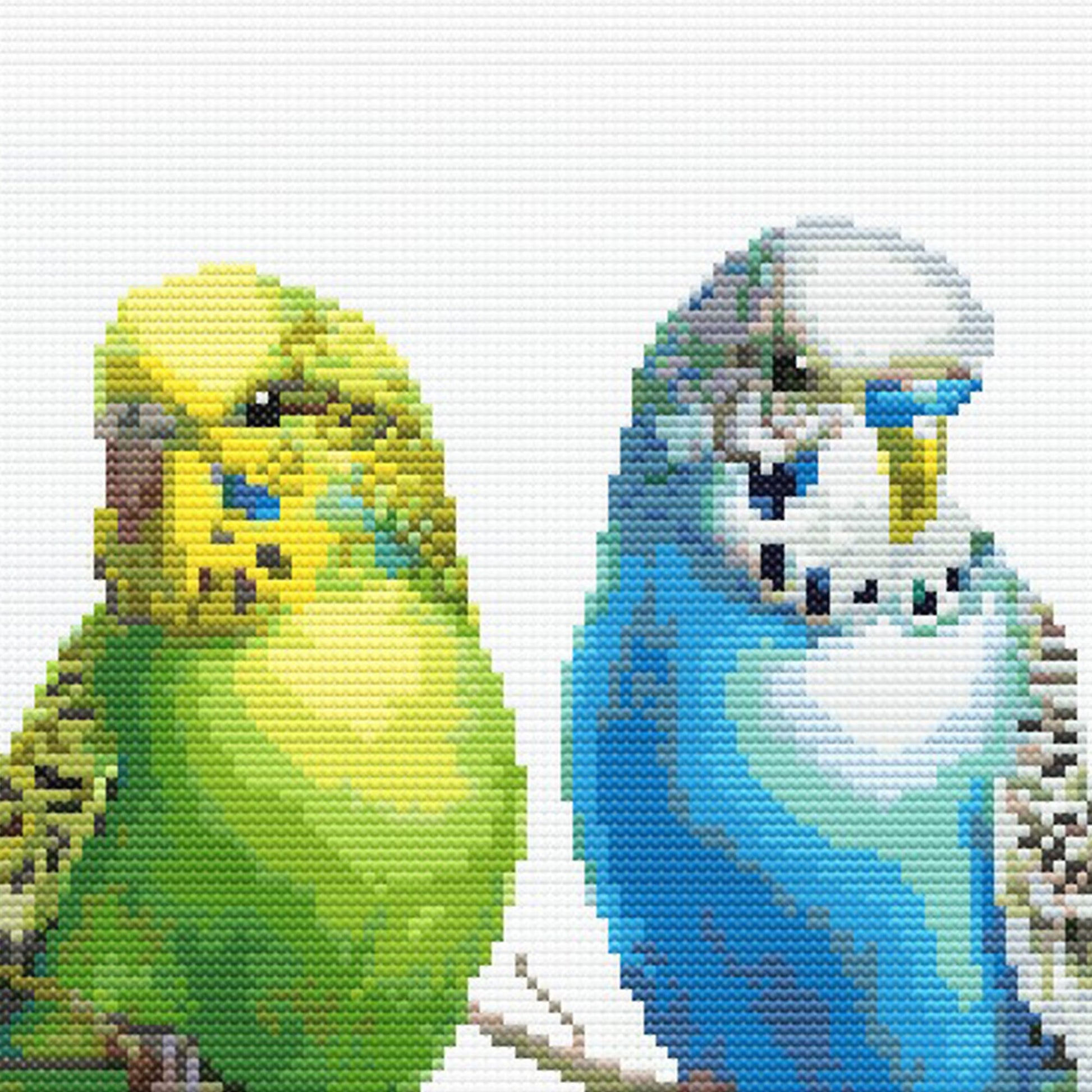 Close-up of Colorful Budgies Cross Stitch Pattern showing yellow and blue budgies, feather detail, and visible counted cross stitch texture.