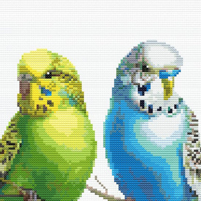Close-up of Colorful Budgies Cross Stitch Pattern showing yellow and blue budgies, feather detail, and visible counted cross stitch texture.