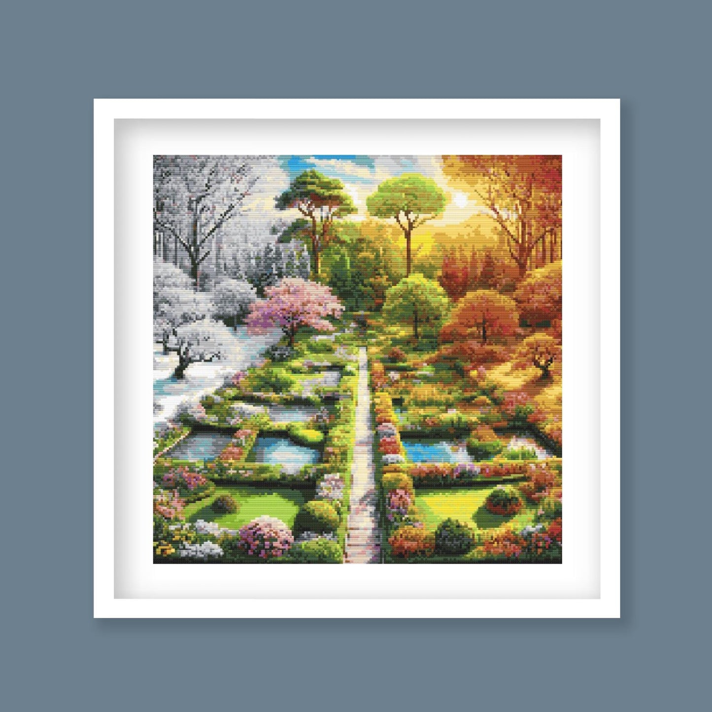 Four Seasons Garden Cross Stitch Pattern displayed as framed wall art with a formal garden path, seasonal trees, flower beds, and colourful landscape detail.