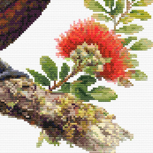 Close-up of New Zealand Kākā Cross Stitch Pattern showing red pōhutukawa flowers, branch detail, greenery, and visible counted cross stitch texture.