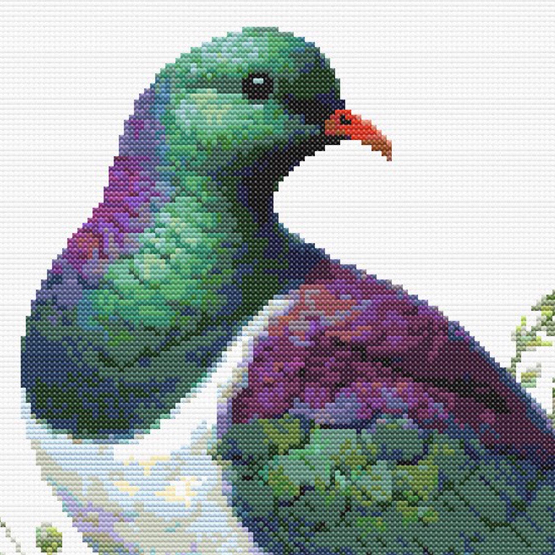 Close-up of New Zealand Kererū Cross Stitch Pattern showing the bird’s green head, purple chest, red beak, and visible counted cross stitch texture.