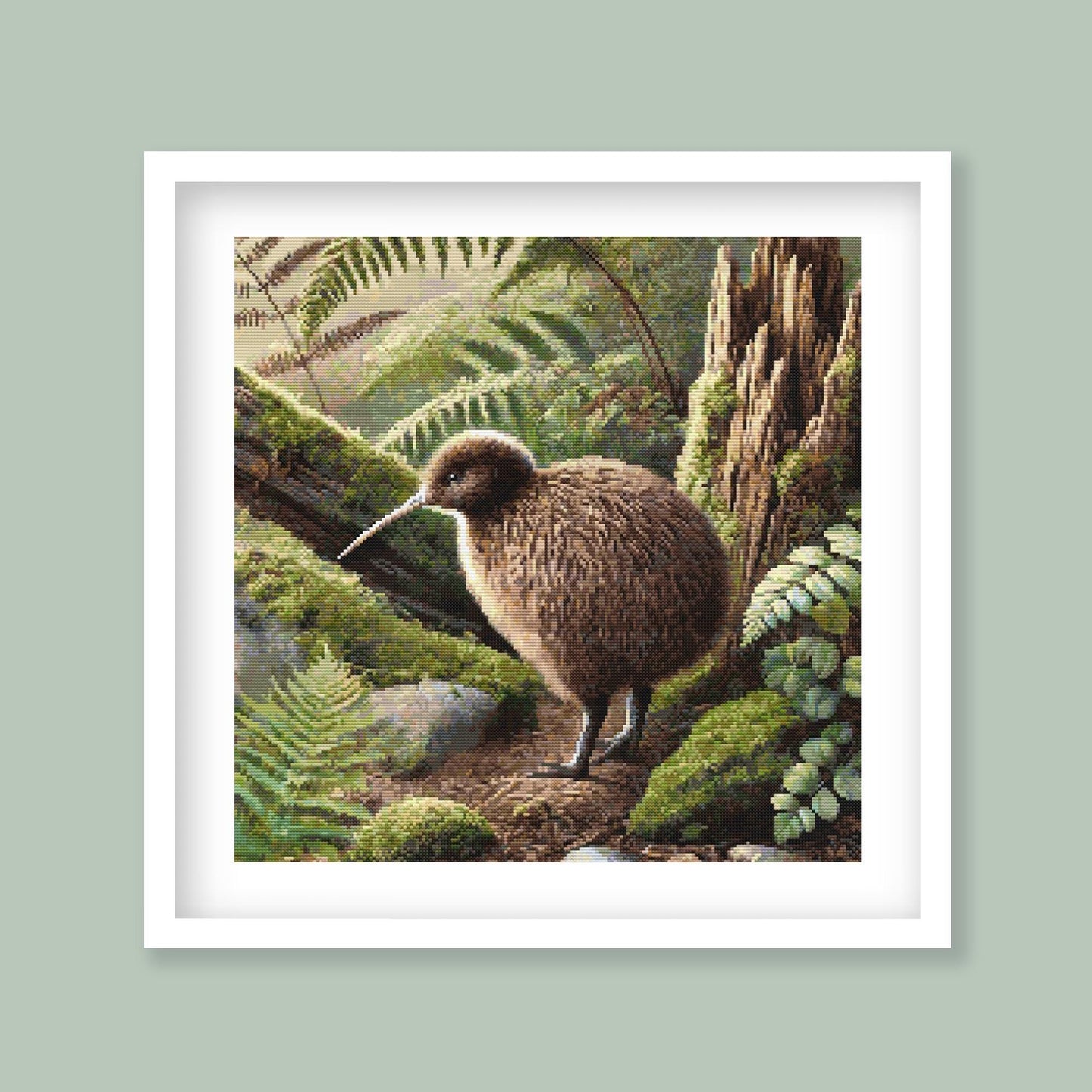 Kiwi Cross Stitch Pattern displayed in a green frame as native New Zealand bird wall art with forest foliage and earthy natural detail.