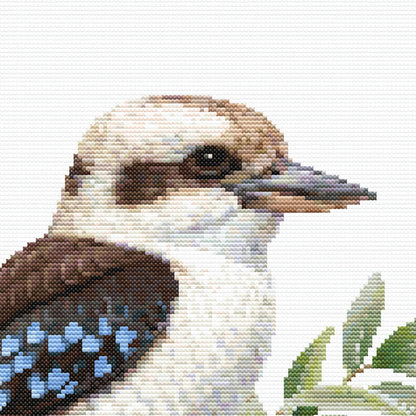 Close-up of Kookaburra Cross Stitch Pattern showing the bird’s face, beak, feather markings, eucalyptus leaves, and visible counted cross stitch texture.