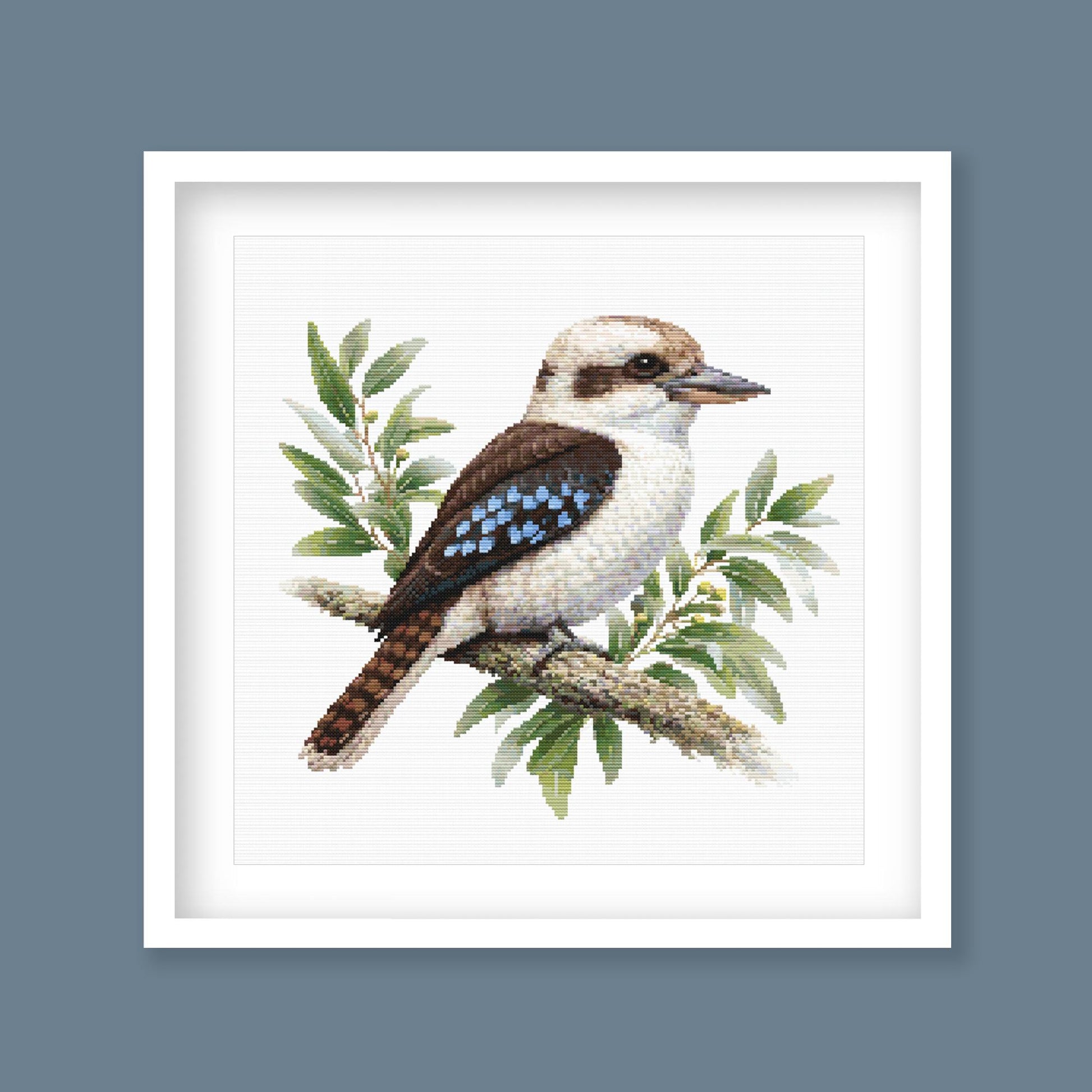 Kookaburra Cross Stitch Pattern displayed as framed wall art with a native Australian kookaburra, eucalyptus leaves, and soft natural bird detail.
