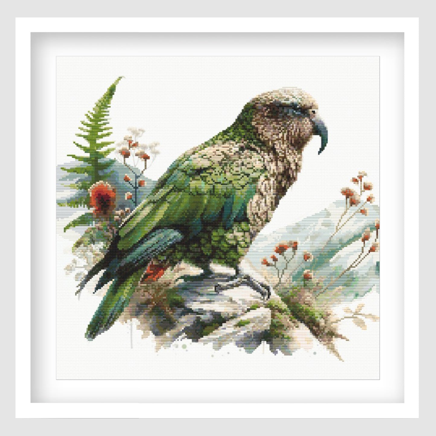 New Zealand Kea Cross Stitch Pattern displayed as framed wall art with a native alpine parrot, green feathers, mountain foliage, and natural New Zealand bird detail.