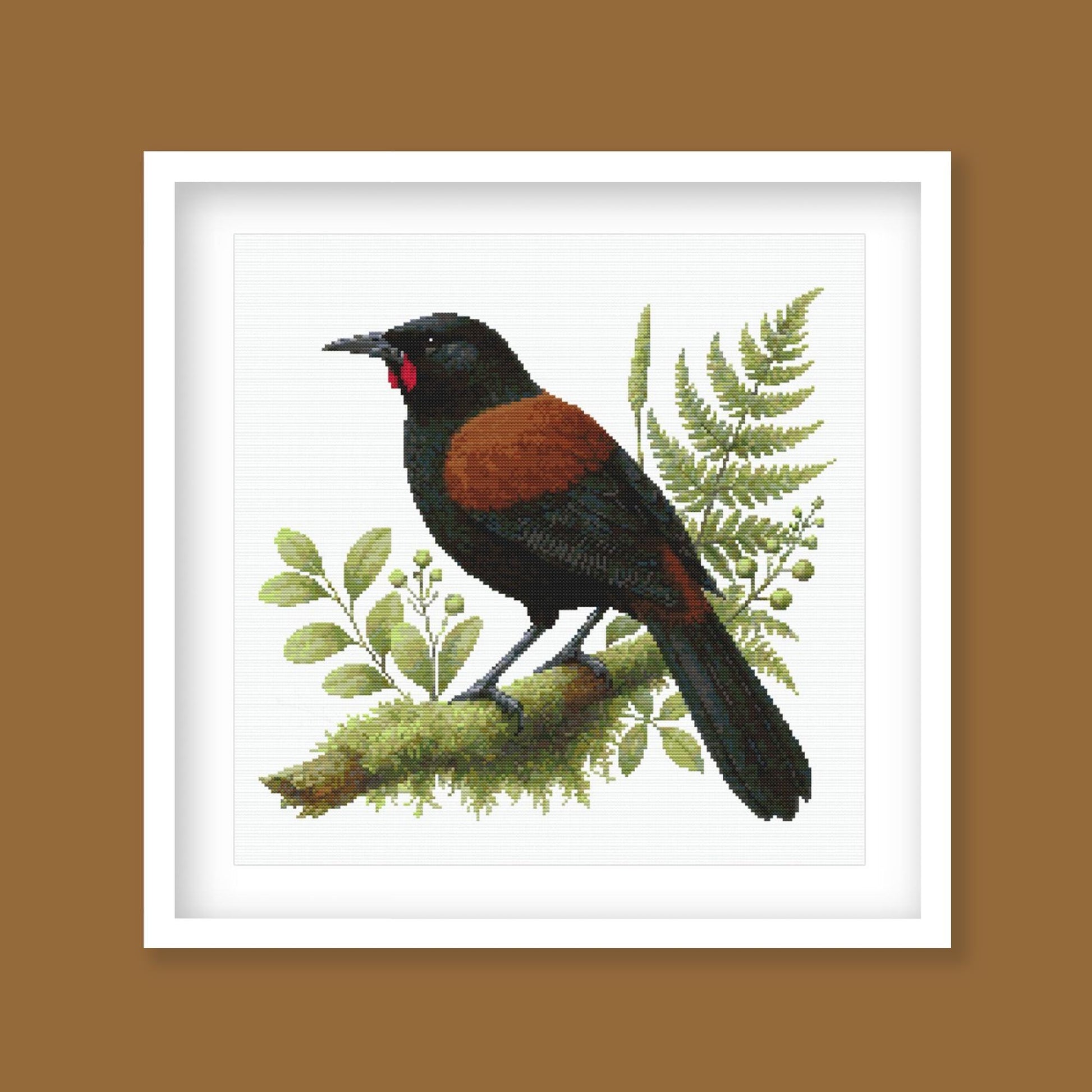 Framed artwork of a New Zealand Saddleback bird on a branch with green leaves and berries on a brown background.