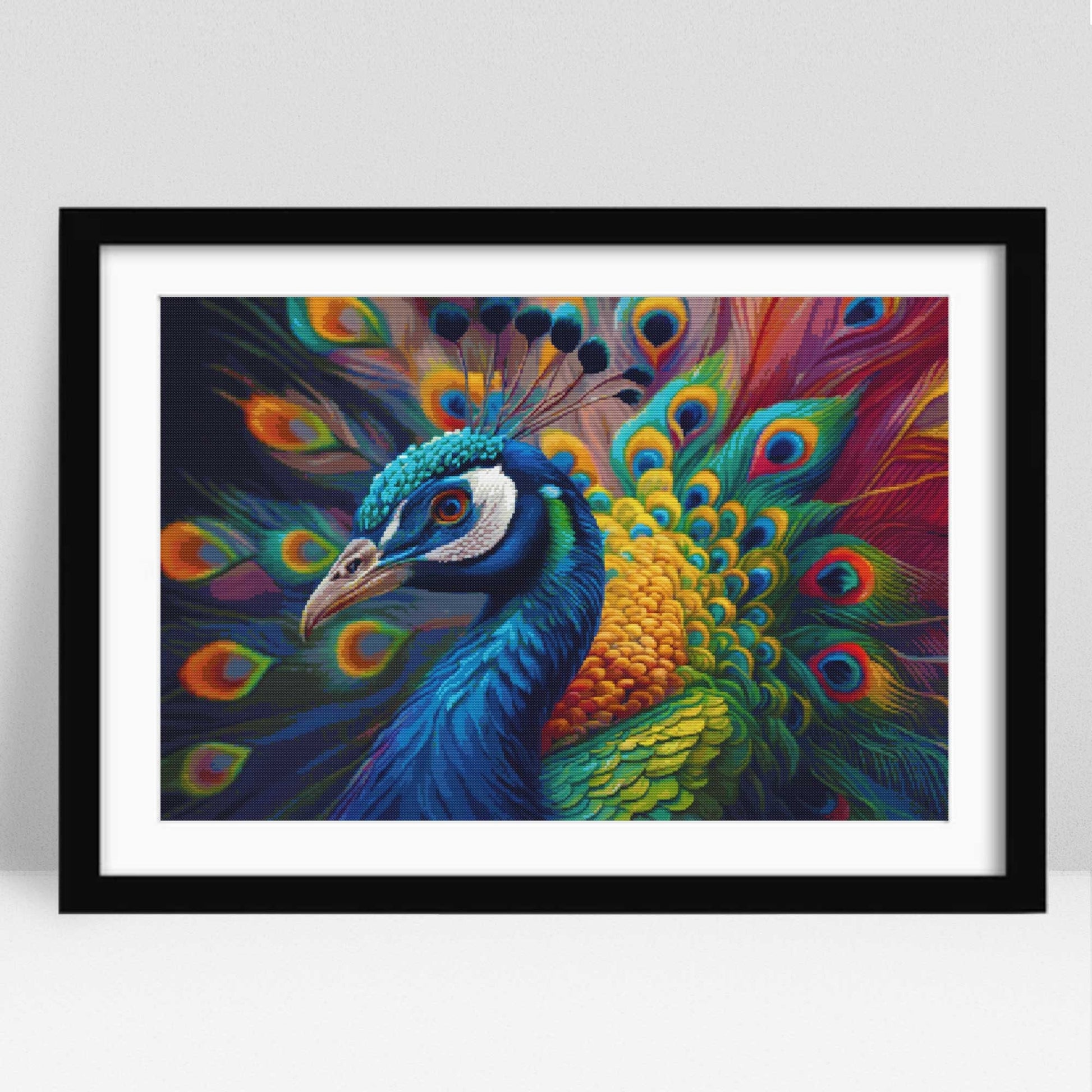 Peacock cross stitch pattern displayed in a black frame as colourful bird wall art with detailed feather design.