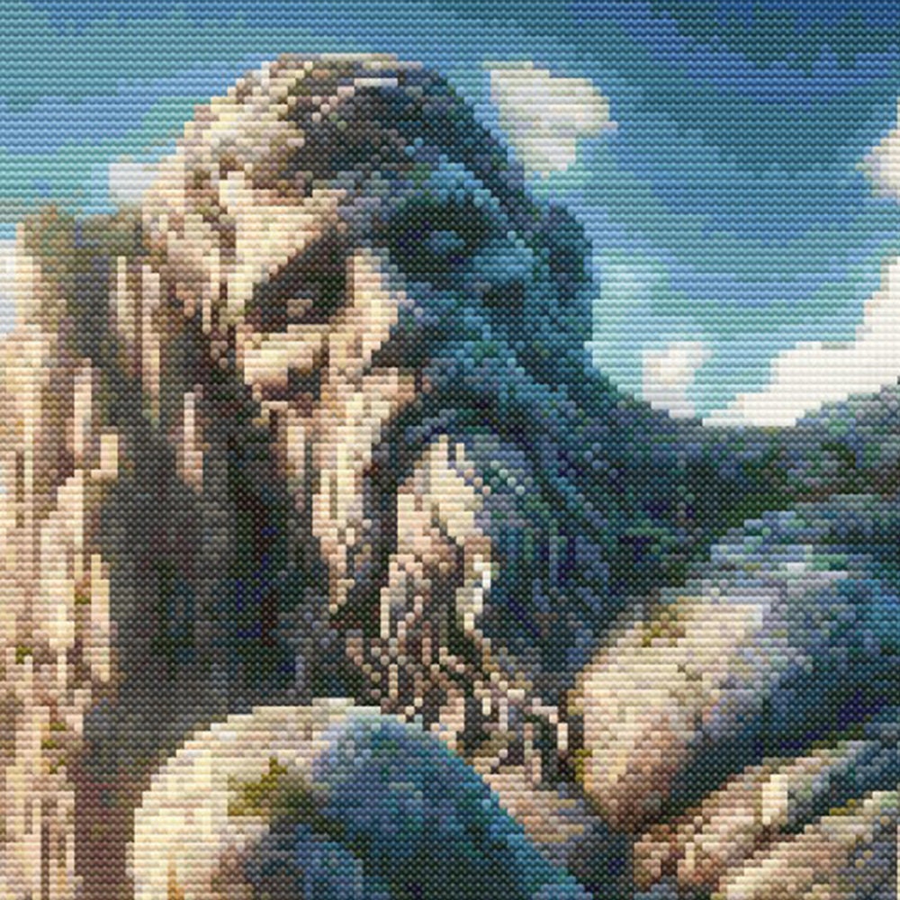Close-up of Majestic Petrified Giant and Castle Cross Stitch Pattern showing the giant stone face, rocky texture, sky detail, and visible counted cross stitch texture.