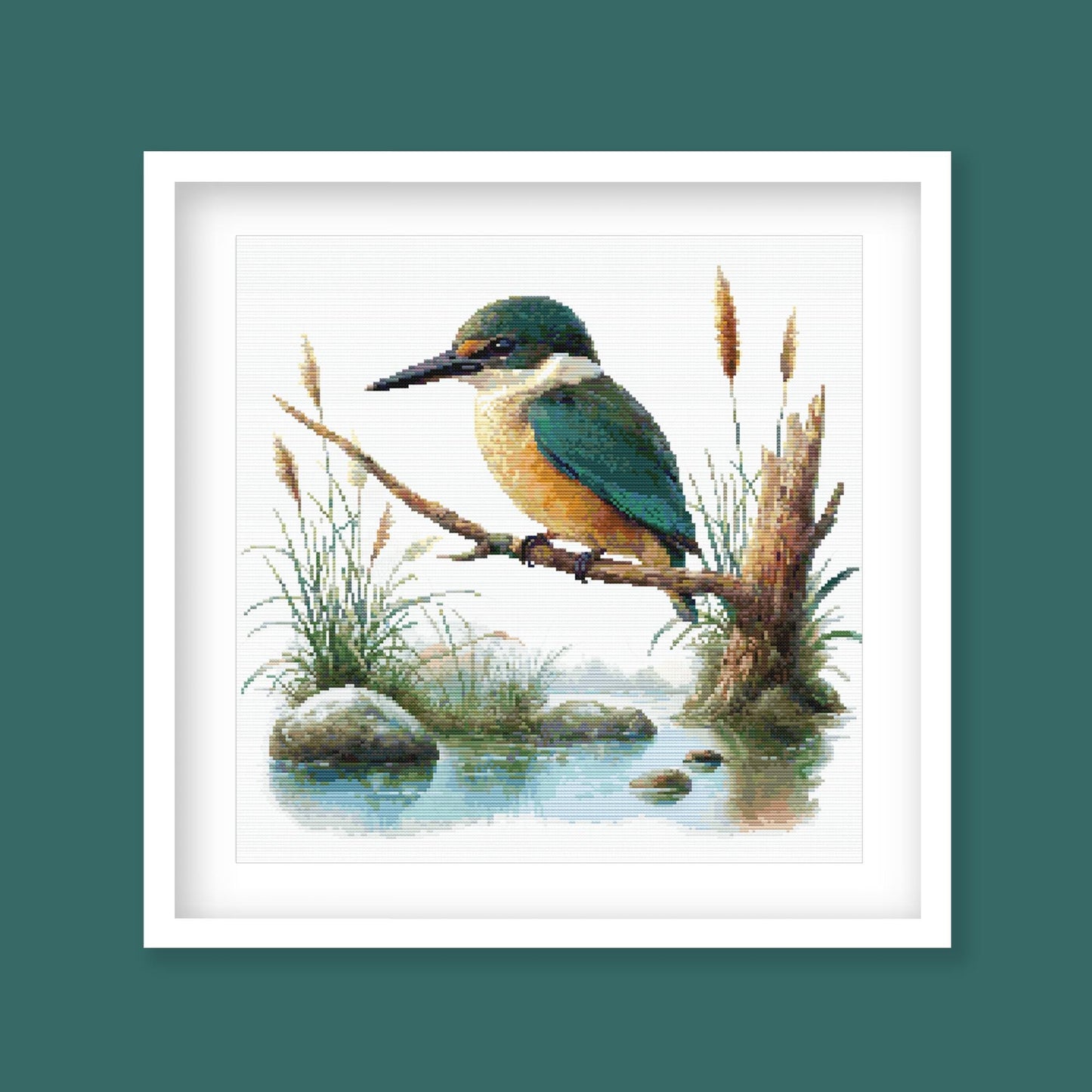 Sacred Kingfisher Kōtare Cross Stitch Pattern displayed in a green frame as native New Zealand bird wall art with wetland-inspired detail.
