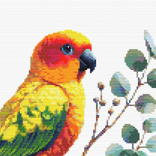 Close-up of Sun Conure Cross Stitch Pattern showing bright orange, yellow, and green feather detail with visible counted cross stitch texture.