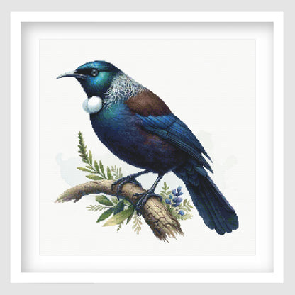 Tui Cross Stitch Pattern displayed as framed wall art with a native New Zealand tui, glossy blue-green feathers, white throat tuft, and natural branch detail.