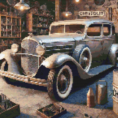 Close-up of Vintage Garage Cross Stitch Pattern showing a classic car, chrome detail, old garage interior, and visible counted cross stitch texture.