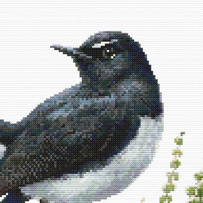 Close-up of Willie Wagtail Bird Cross Stitch Pattern featuring the bird’s black-and-white markings, eye detail, and textured stitching.