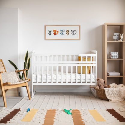 Cute Woodland Animal Cross Stitch Pattern shown in a nursery room preview as playful animal wall art above a cot.