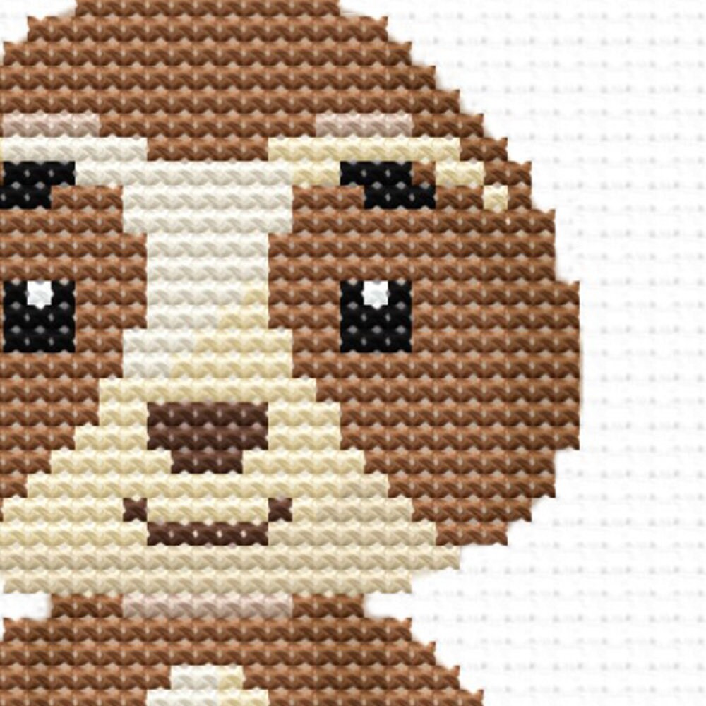 Close-up of Cute Woodland Animal Cross Stitch Pattern showing a monkey design with brown tones and visible counted cross stitch texture.